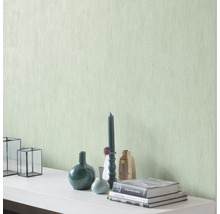 Decoratieve muur met structuurbehang en woonaccessoires zoals vazen, kaarsen en boeken