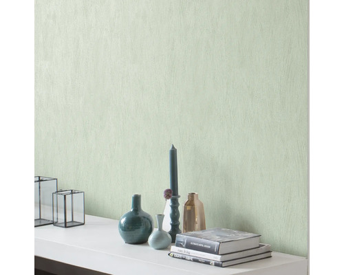 Decoratieve muur met structuurbehang en woonaccessoires zoals vazen, kaarsen en boeken