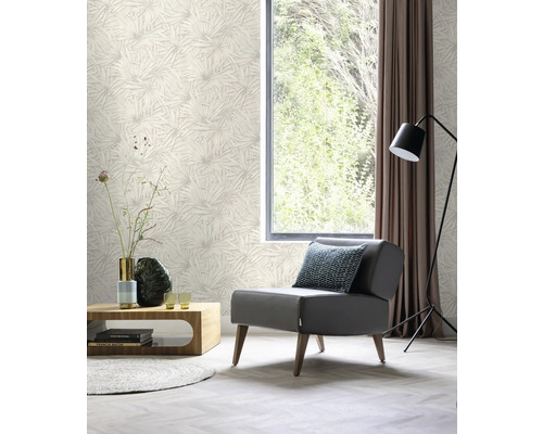 Woonkamer met patroonbehang, fauteuil, tafel, lamp en gordijn