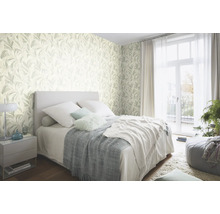 Slaapkamer met behang met bladmotief, bed en nachtkastje