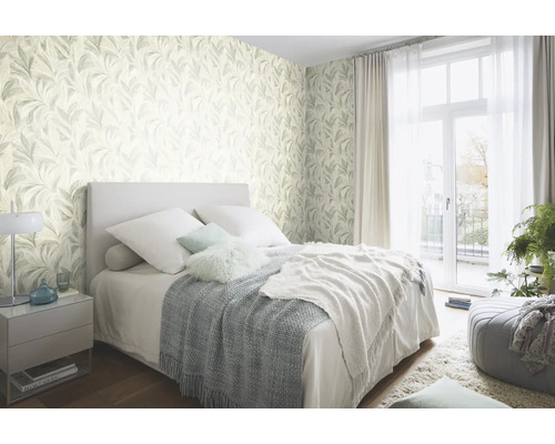 Slaapkamer met behang met bladmotief, bed en nachtkastje