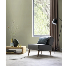 Woonkamer met fauteuil, salontafel, staande lamp en raam voor een lichte sfeer