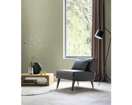 Woonkamer met fauteuil, salontafel, staande lamp en raam voor een lichte sfeer