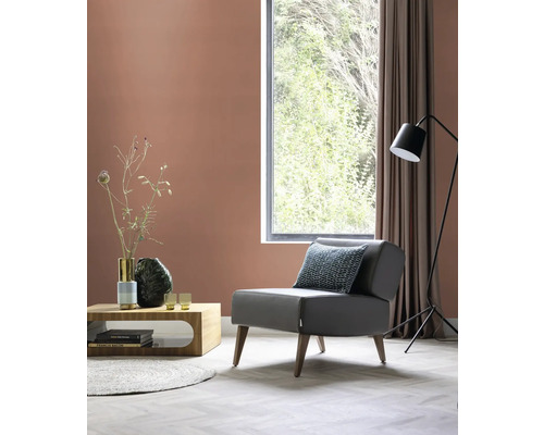 Woonkamer met fauteuil, tafel, staande lamp en decoratie