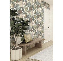 Decoratief behang met bladerpatroon achter houten kruk met kussens en kamerplant in gevlochten mand