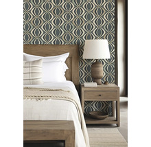 Slaapkamer met bed, nachtkastlamp en behang met patroon