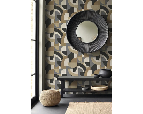 Woonkamer met geometrisch behang, ronde spiegel en decoraties op een tafel