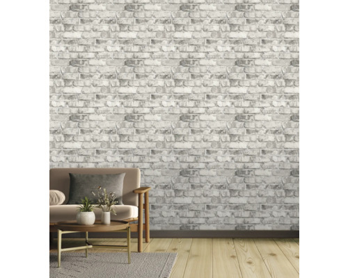 Woonkamer met grijs baksteenbehang, bank, tapijt en houten vloer