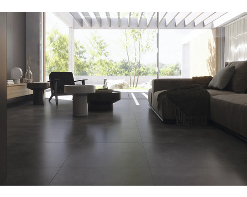 Lichte woonkamer met donkere tegelvloer, bank en fauteuils