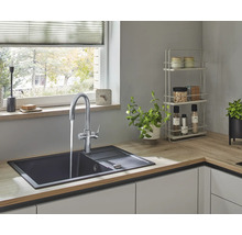 Keukenspoelbak met kraan in een lichte keuken.