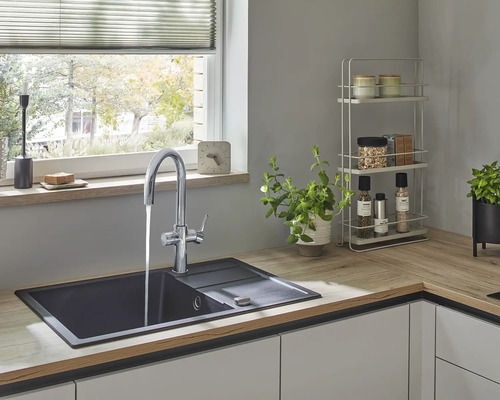 Keukenspoelbak met kraan in een lichte keuken.