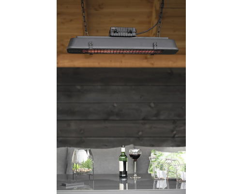 Hangende terrasverwarmer boven een tafel met drankjes en decoratie.