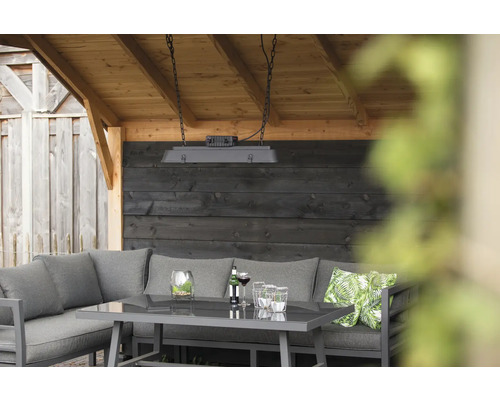 Tuin lounge set met tafel, hoekbank, sierkussens en hanglamp onder een houten overkapping