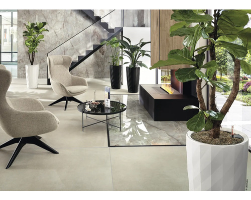 Modern interieur met fauteuils, tafel, planten en open haard.