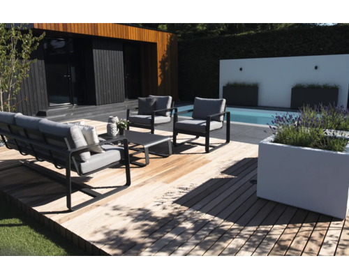 Tuinmeubelset op houten terras naast zwembad en huis