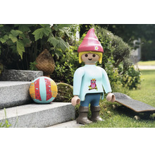Playmobil speelfiguur met bal en skateboard in de tuin