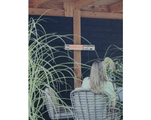 Terrasscène met terrasverwarmer, rotanmeubels en decoratieve grassen