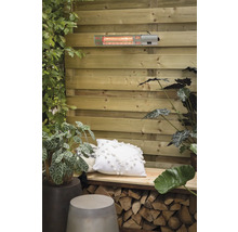 Terrasscène met terrasverwarmer aan houten wand, gedecoreerd met planten en kussens