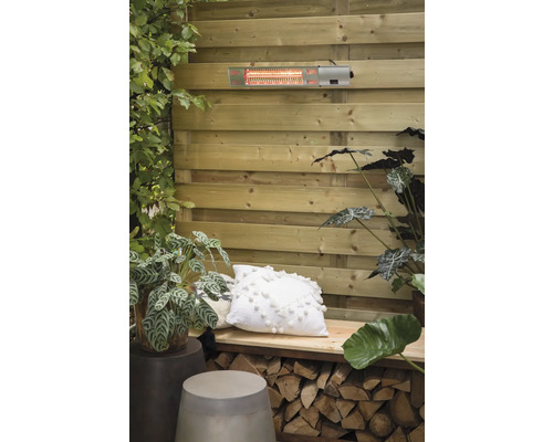 Terrasscène met terrasverwarmer aan houten wand, gedecoreerd met planten en kussens