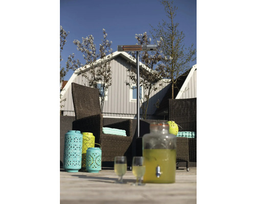 Terras met terrasverwarmer, rotan stoelen, lantaarns en drankdispenser voor een gezellige sfeer