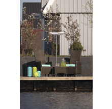 Terrasscène met rotan stoelen, tafel, terrasverwarmer en decoratieve lantaarns aan het water