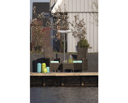 Terrasscène met rotan stoelen, tafel, terrasverwarmer en decoratieve lantaarns aan het water