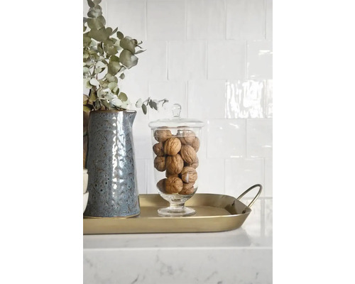 Decoratieve opstelling met kruik, eucalyptus, glazen pot en walnoten op een gouden dienblad