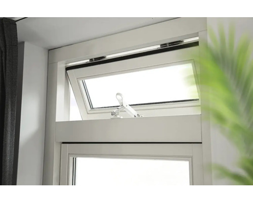 Gekanteld raam met raamgreep in een lichte kamer