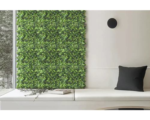 Decoratieve groene plantenwand naast zithoek met kussens