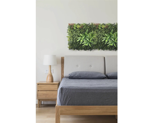 Slaapkamer met bed, nachtkastje en kunstmatige plantenwanddecoratie