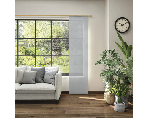 Woonkamer met schuifpaneel, bank, klok en kamerplanten