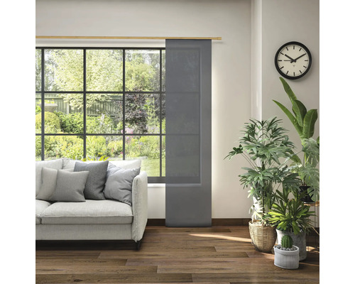 Woonkamer met schuifpaneel voor het raam, bank en kamerplanten