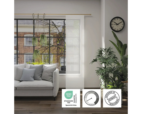 Woonkamer met bank en transparant paneelgordijn met keurmerk Öko-Tex Standard 100, transparantiesymbool en keurmerk Designed in Germany.