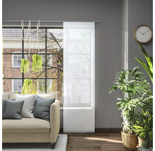 Woonkamer met bank en transparant schuifgordijn voor het raam om het licht te regelen.