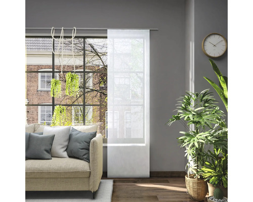 Woonkamer met bank en transparant schuifgordijn voor het raam om het licht te regelen.