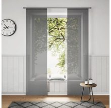 Woonkamer met schuifgordijnen voor het raam, klok en vloerkleed