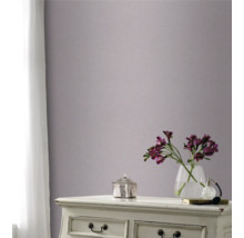 Decoratieve kamer met patroonbehang op de muur, ladekast, bloemenvaas en gordijn voor het raam.