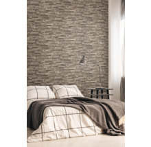 Slaapkamer met steenlook behang, bed, nachtkastje en lamp.