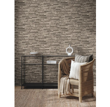 Woonkamer met steenlook behang, rek en rotan stoel