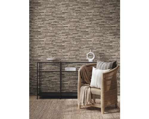 Woonkamer met steenlook behang, rek en rotan stoel