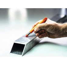 Hand die met een stift een lijn trekt op een metalen buis.