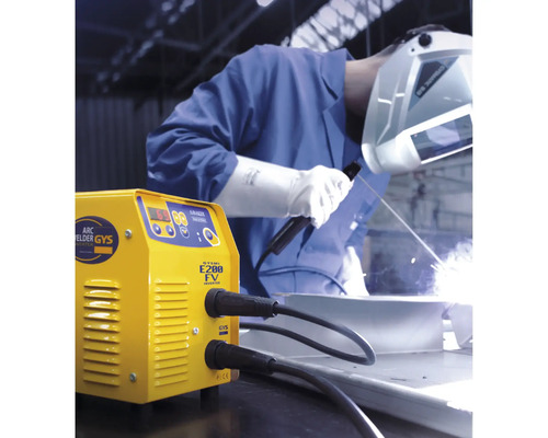 Geel lasapparaat tijdens het lassen door een persoon met een lashelm.