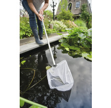 Vrouw gebruikt een schepnet in een tuinvijver
