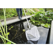 Persoon met schepnet voor het schoonmaken van een tuinvijver