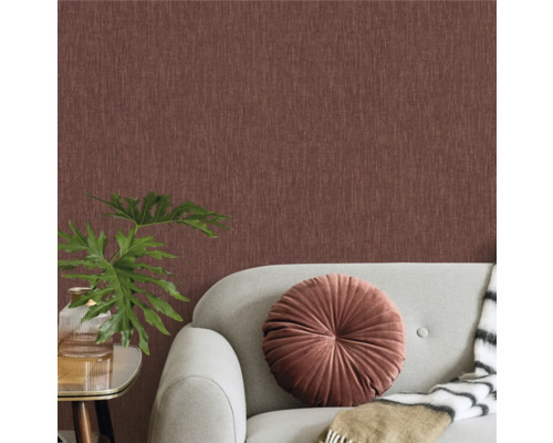 Woonkamer met textielbehang, bank, kussen en kamerplant