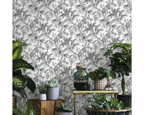 Scene met een behang met plantmotieven en verschillende kamerplanten op meubels.
