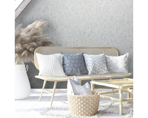 Decoratieve scène met rotan bank, kussens, rotan tafel en bloemenvaas voor een bloemenbehang