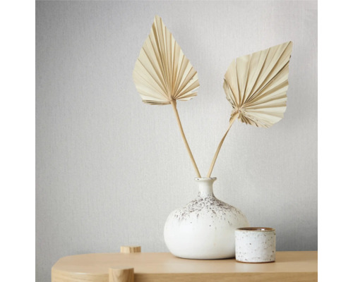 Decoratieve gedroogde palmbladeren in een witte vaas op een tafel