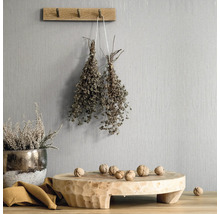 Decoratieve scène met houten elementen, kruiden en noten tegen een gestructureerde wand
