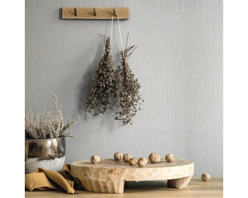 Decoratieve scène met houten elementen, kruiden en noten tegen een gestructureerde wand